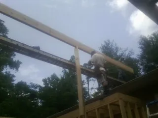 Carpenter setting a ridge beam over a new addition frame — Ice Dam Removal by Roofing Brothers in Lupton City