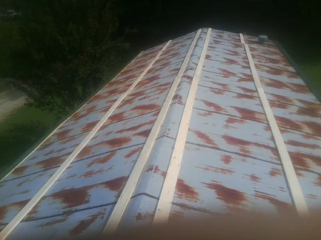 Rusted metal roof panels with new wood purlins before replacement — Storm Damage Roof Repair in Lupton City by Roofing Brothers