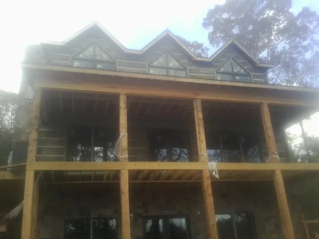 Dormers and porch framing on a large log home under construction — Roof Coating work by our crew in Lupton City