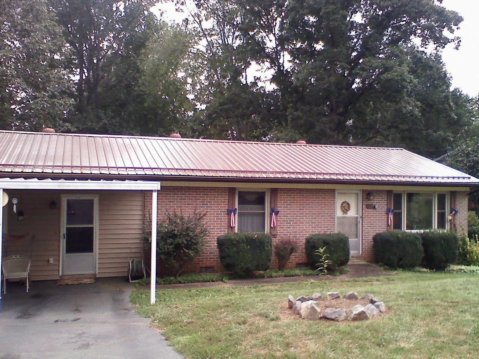 Bronze metal roof and carport on a brick ranch home — Roof Repair work by our crew in Lupton City