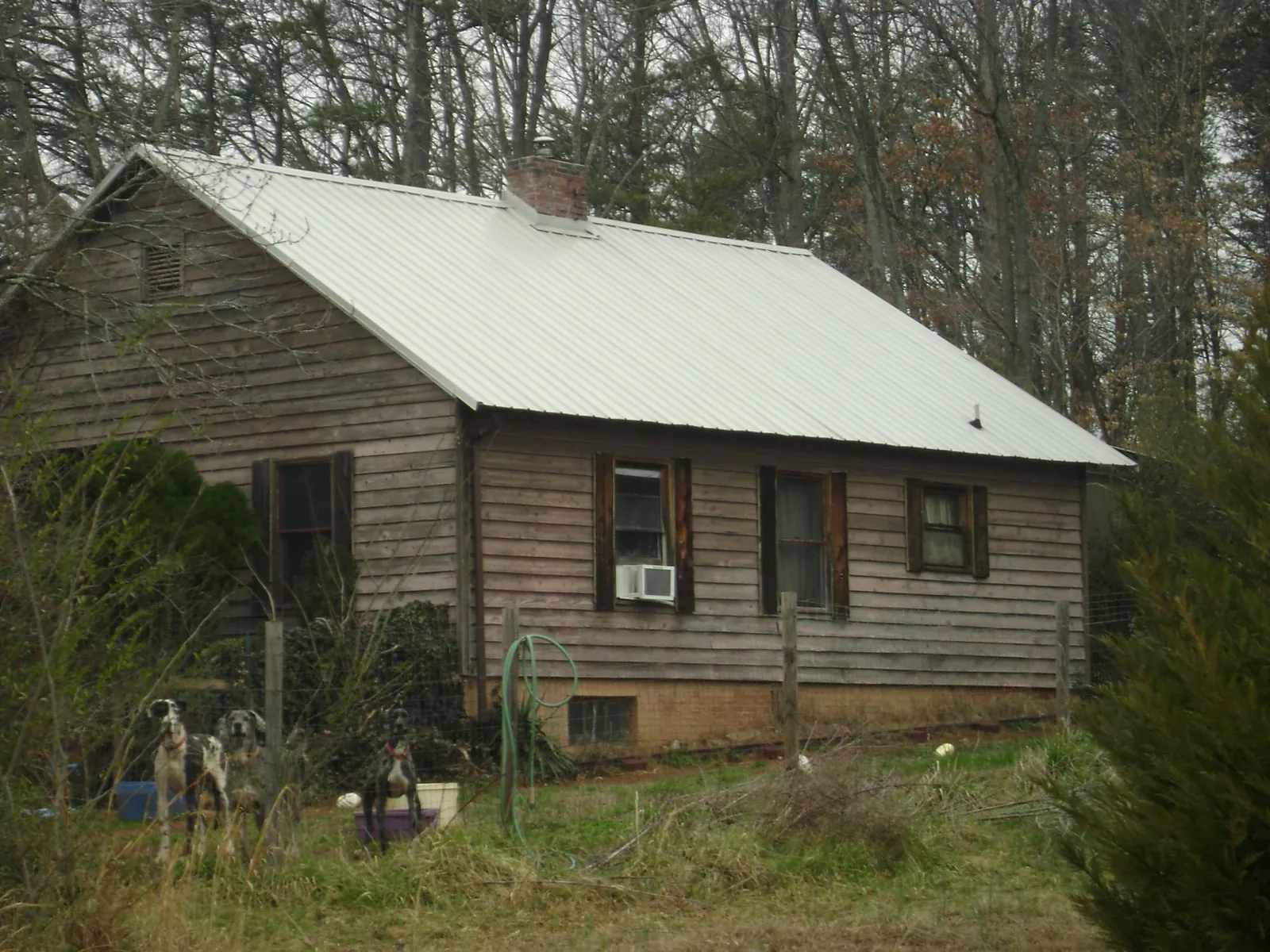 White metal roof on an old wood sided farmhouse, from a Asphalt Shingle Roof Repair job in Lupton City